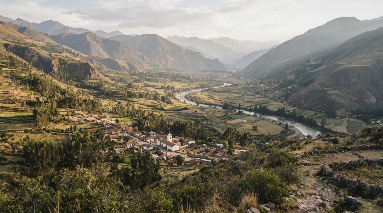 Terraced Inca fields and the Urubamba River winding through the Sacred Valley on a sacred valley tour from Cusco, Peru